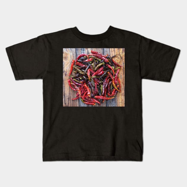 Dried chili peppers on a wooden board Kids T-Shirt by naturalis